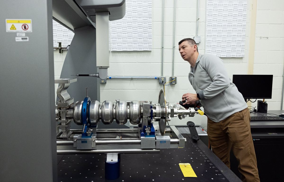 CMM operator running an inspection program on a bridge coordinate measuring machine