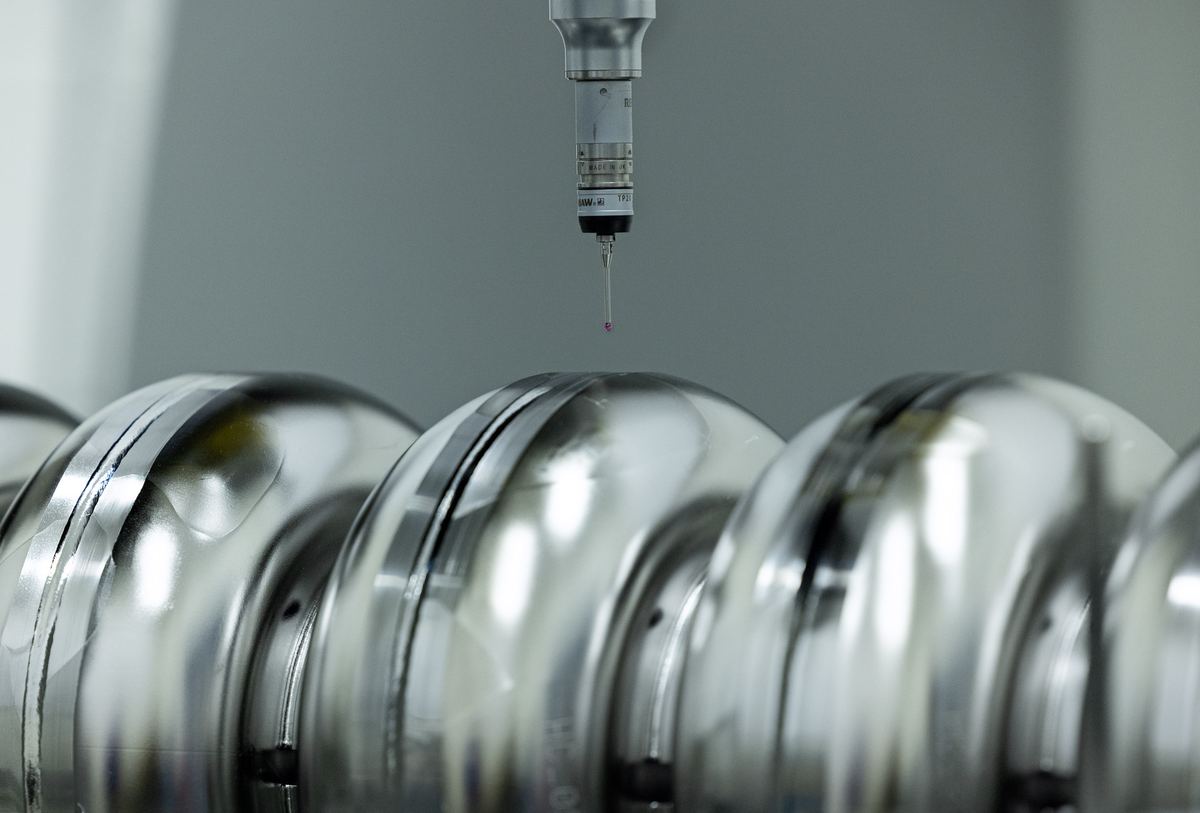CMM probe positioned over polished precision components during inspection